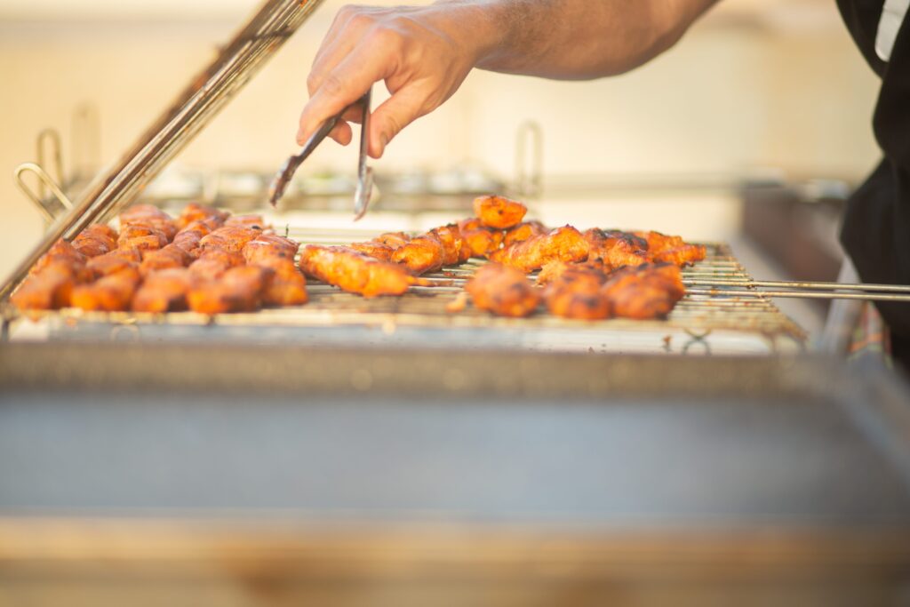 Persona haciendo carne en una barbacoa